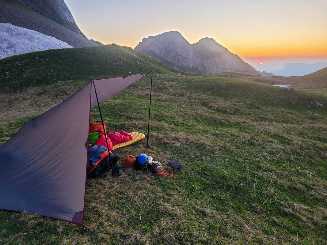 materiel parapente vol bivouac v2-8 coucher de soleil sur le bivouac qui a été atteint en parapente. Le tarp protège contre le vent qui descend de la montagne. Panorama de montagne de rêve pour ce vol bivouac en parapente