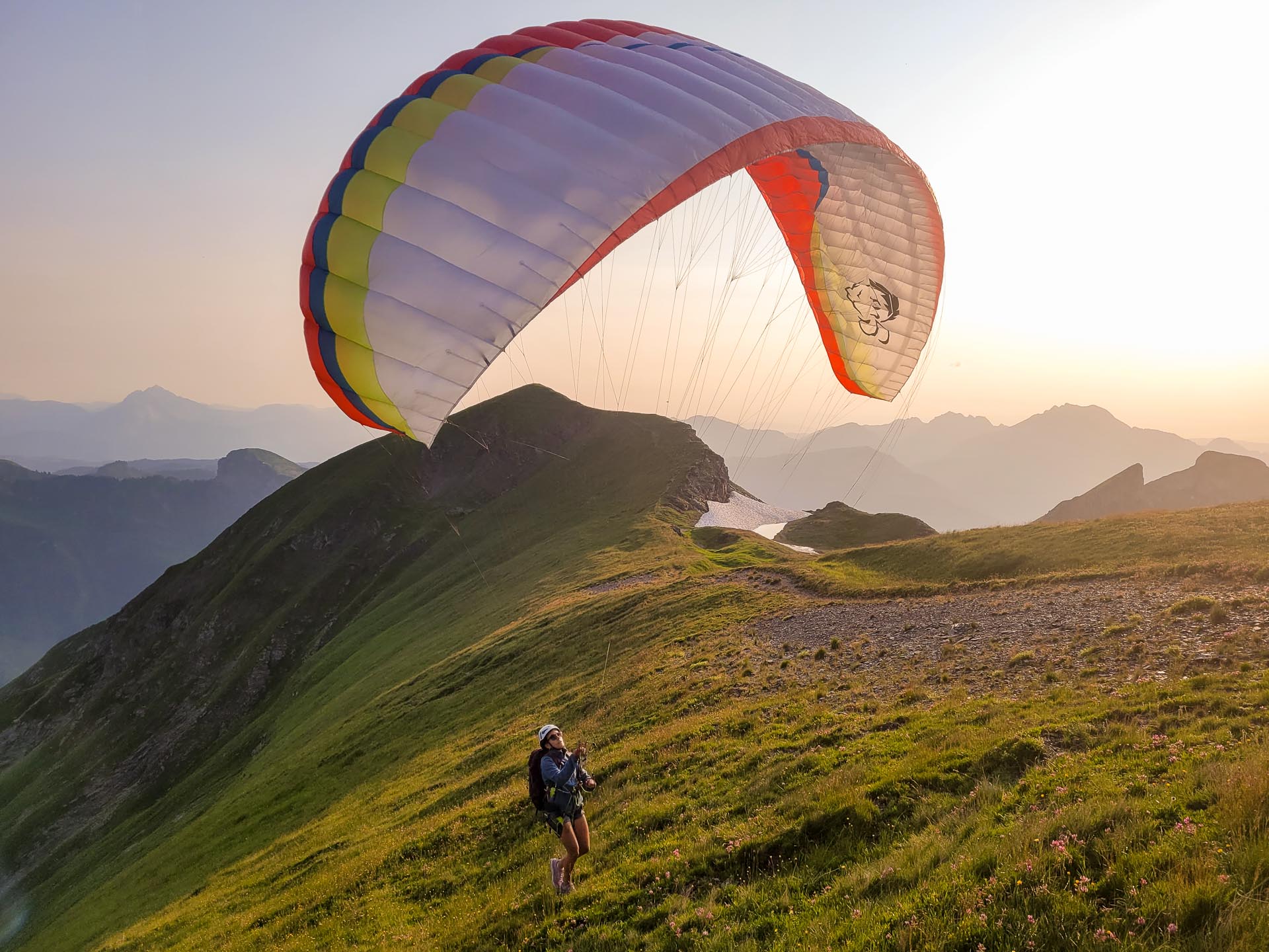 stage-1 Gonflage d'un parapente de montagne au coucher de soleil sur une crête