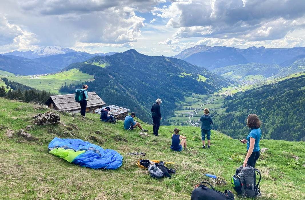 les pilotes qui analysent les conditions aérologiques et météorologiques avant de décoller lors d'un vol rando du stage de parapente vol montagne autonomie.
