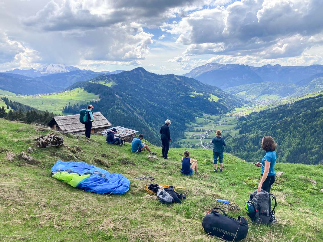 stage parapente montagne feminin-1 les pilotes qui analysent les conditions aérologiques et météorologiques avant de décoller lors d'un vol rando du stage de parapente vol montagne autonomie.