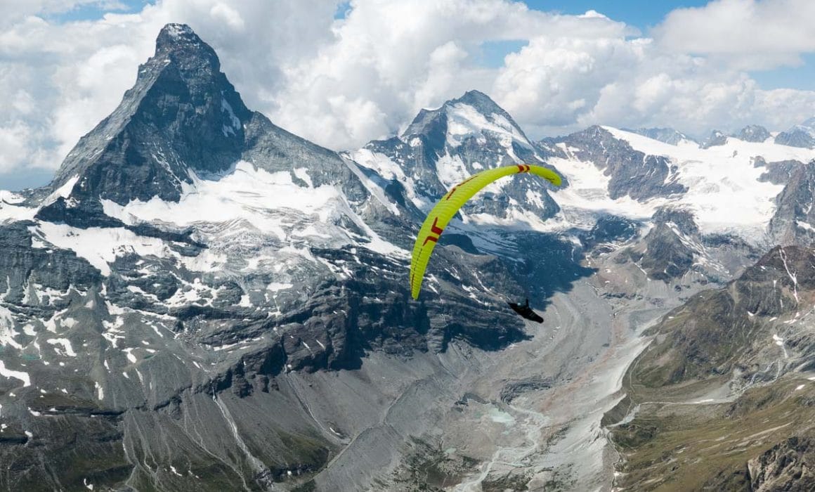 En parapente devant le Cervin et la dent d'hérens au cours d'un vol bivouac en suisse au dessus des glaciers
