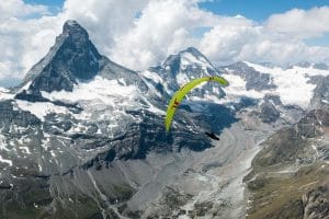 En parapente devant le Cervin et la dent d'hérens au cours d'un vol bivouac en suisse au dessus des glaciers